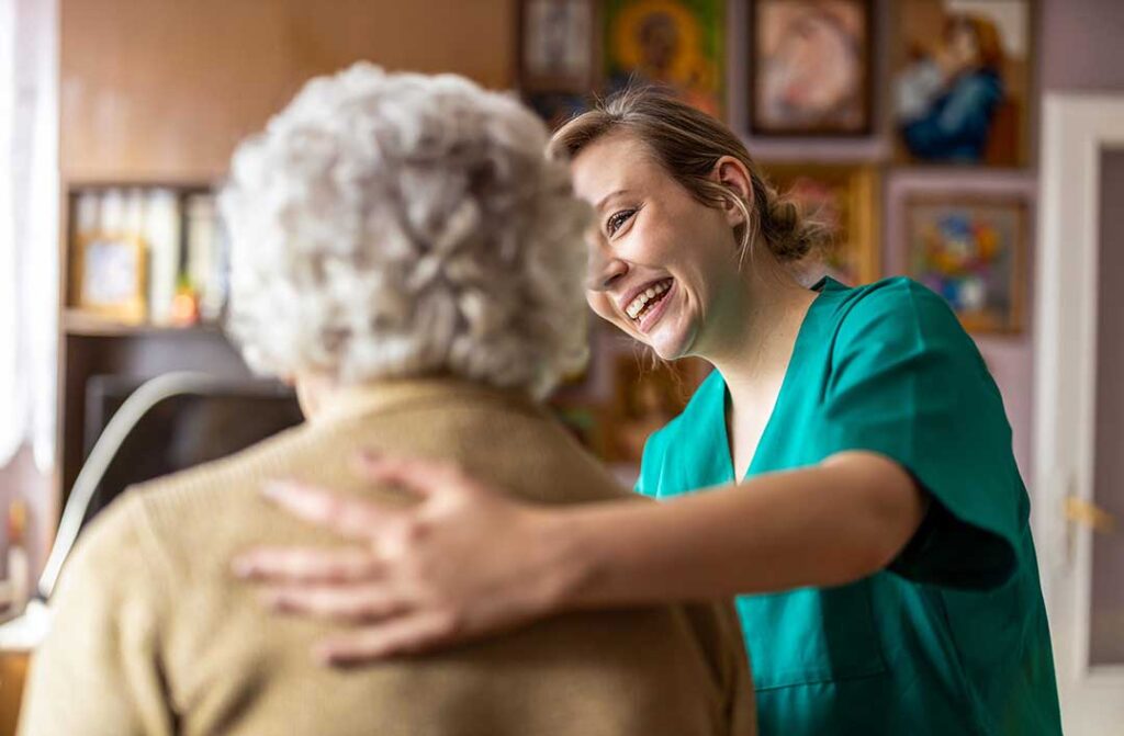Older adult walking with a cane while navigating a clear, well-lit hallway with supportive handrails.