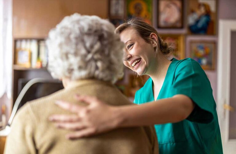 Older adult walking with a cane while navigating a clear, well-lit hallway with supportive handrails.